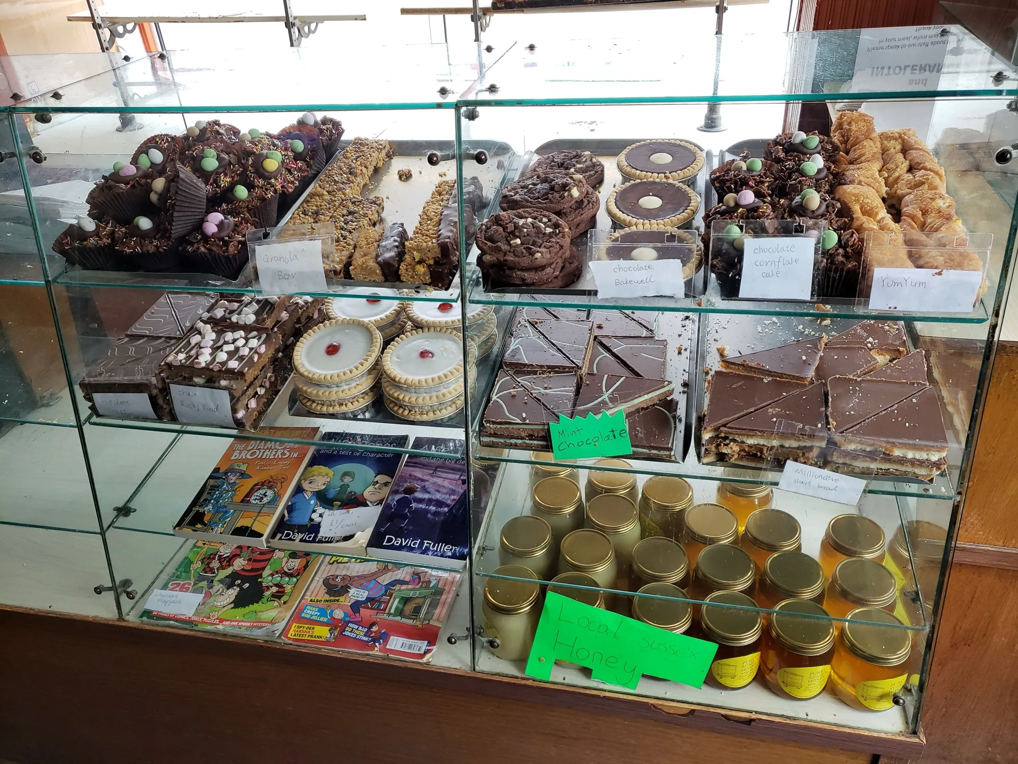 A glass bakery case filled with brownies, tarts, and cookies