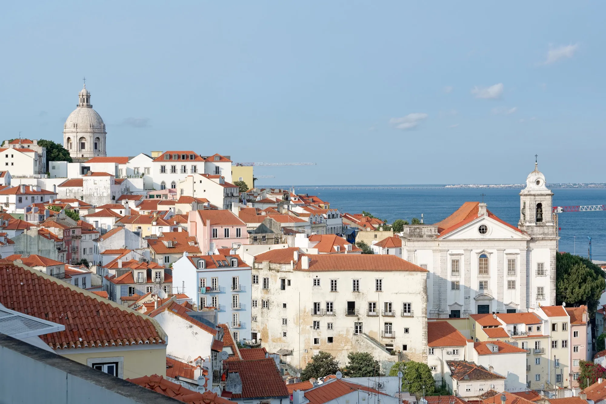 Rooftops of the Alfama district in Lisbon with the Tagus River behind